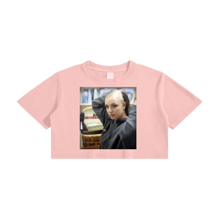 brittany spears with a half shaved head on a gray, pink, tan and orange crop top.